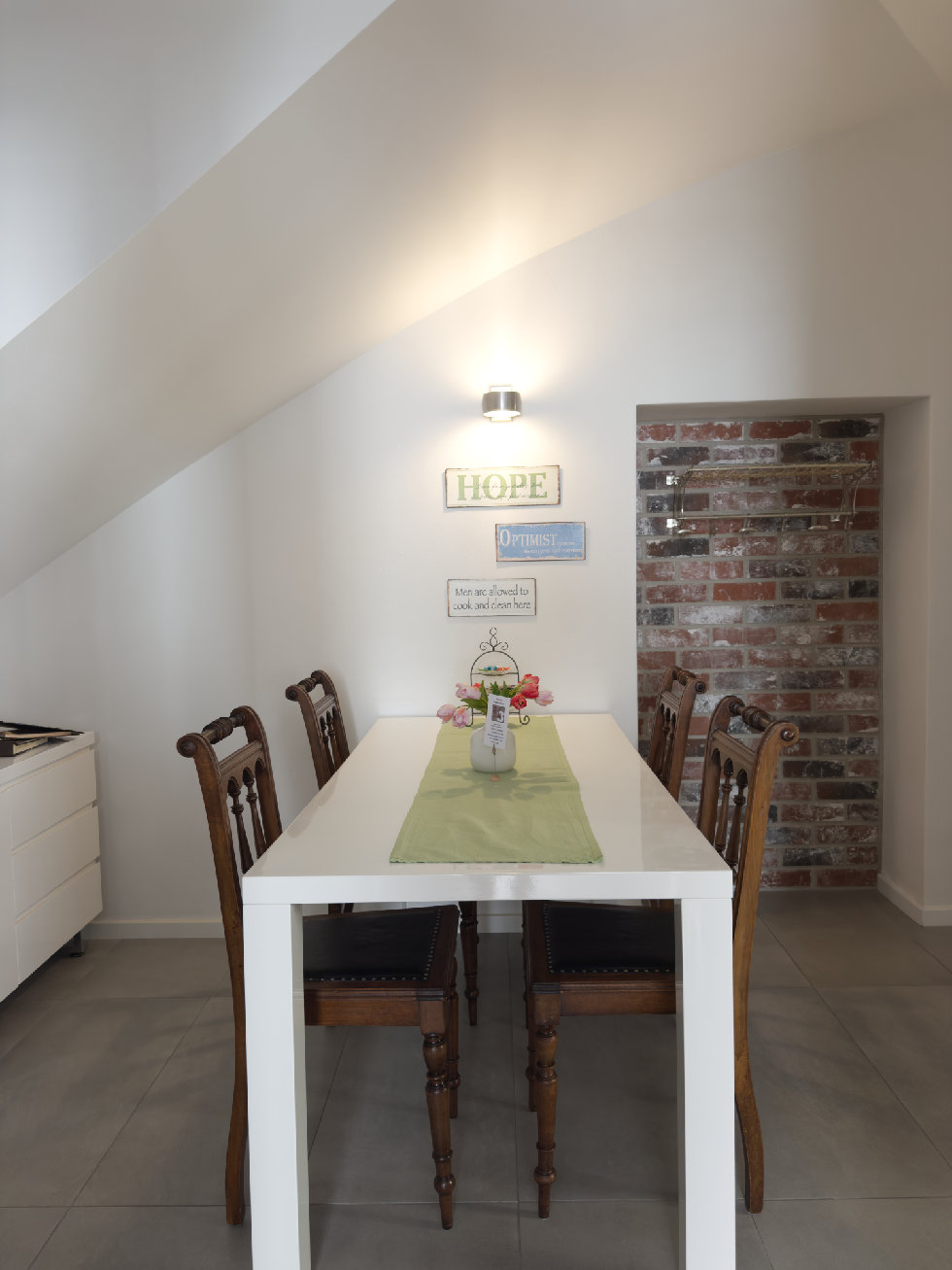 Blick in den Flur mit weißem Tisch und vier Holzstühlen