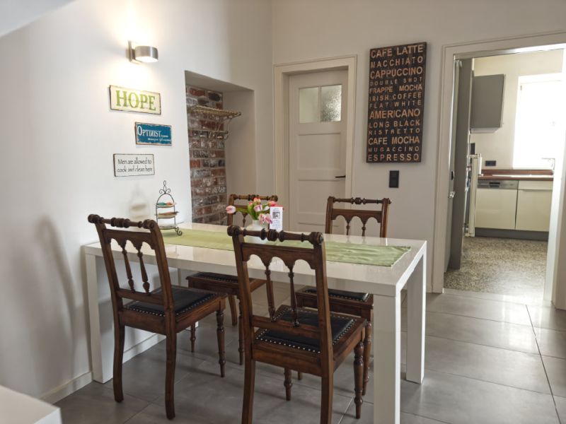 Heller Essbereich der Ferienwohnung mit Sitzgelegenheiten für 4 Personen und offenem Übergang zur modernen Küche.