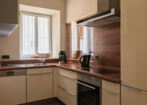 Blick in die Küche mit hellen Fronten und holzfarbener Arbeitsplatte