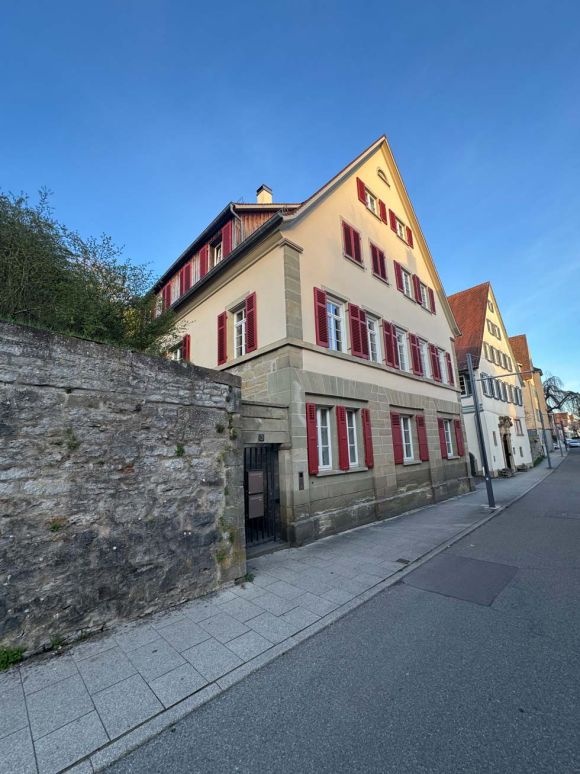 Blick auf das Haus mit roten Fensterläden